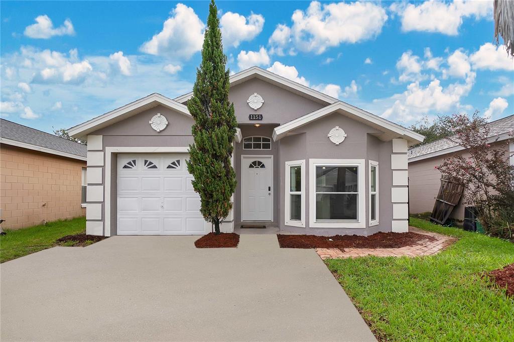 a front view of a house with a yard and garage