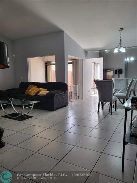 a living room with furniture a dining table and a window