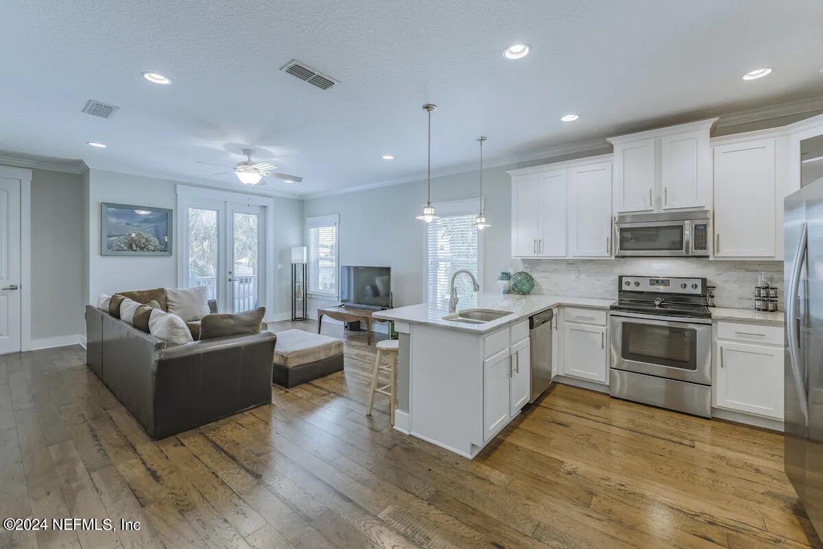 a kitchen with furniture a refrigerator and a stove top oven