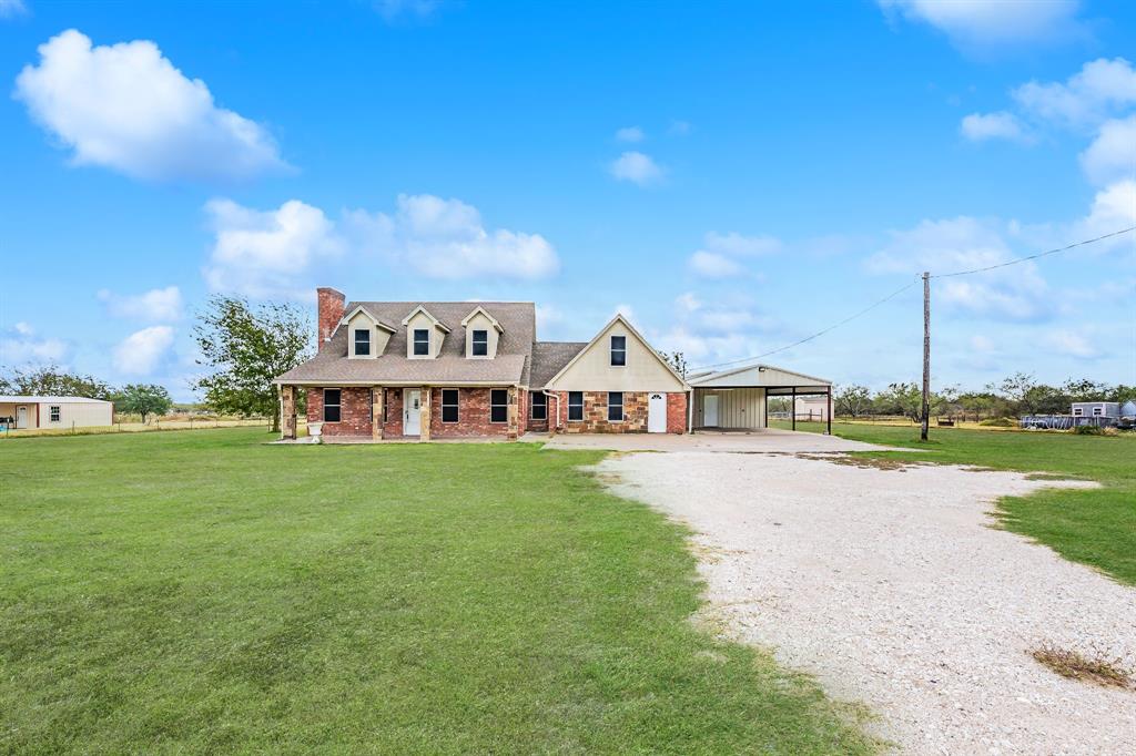 a view of a house with a yard and sitting area