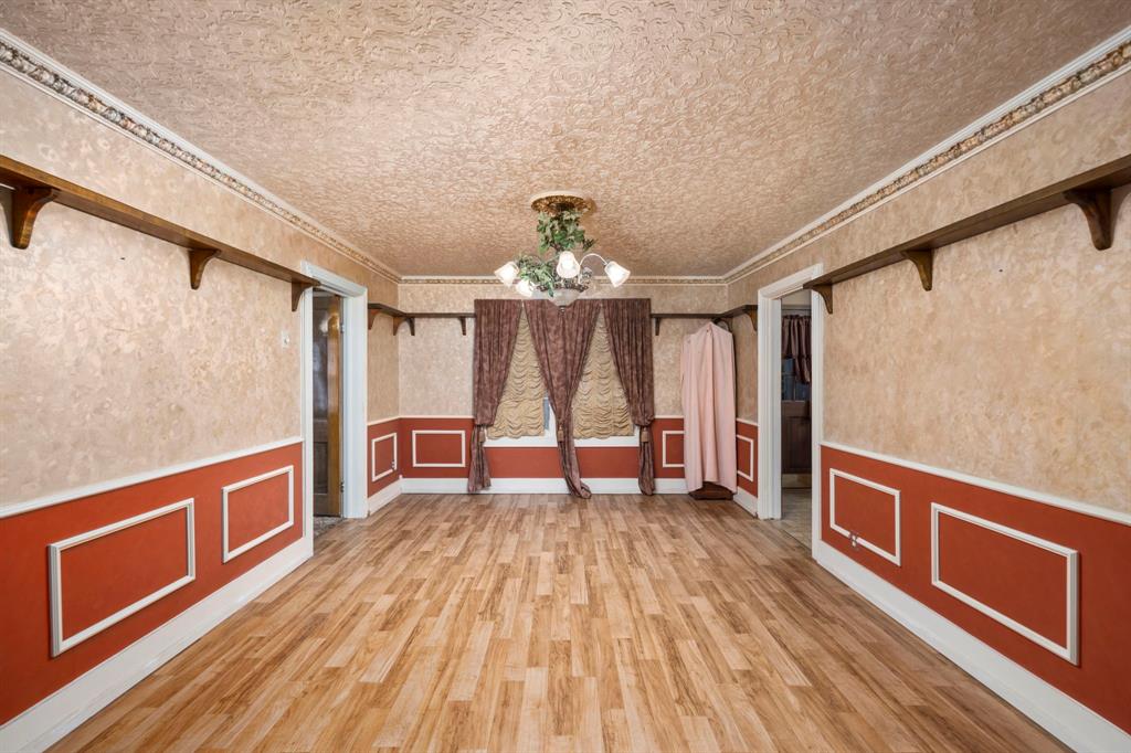 a living room with stainless steel appliances granite countertop a dishwasher a stove and a wooden floors