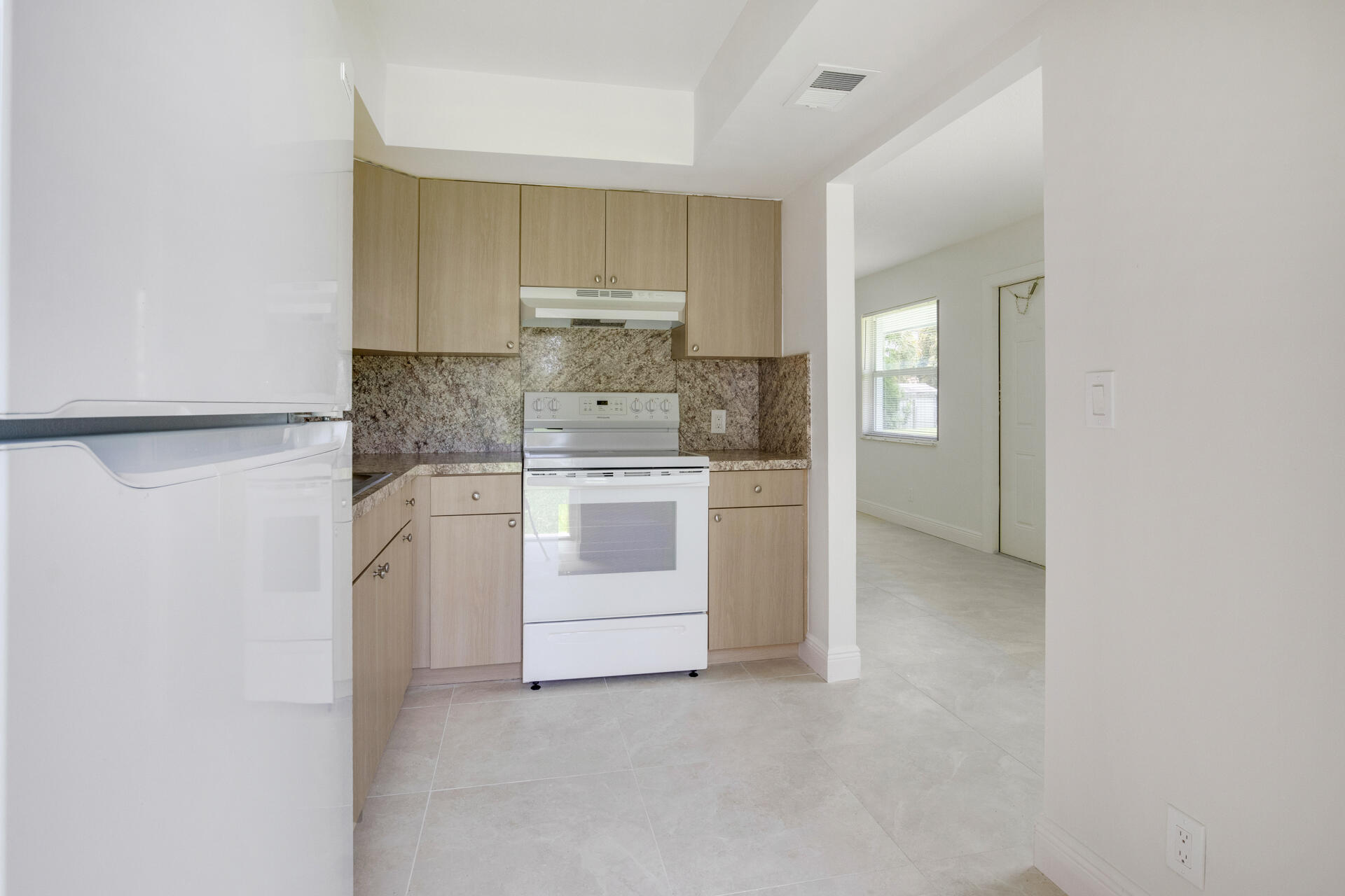 a kitchen with white cabinets and white appliances