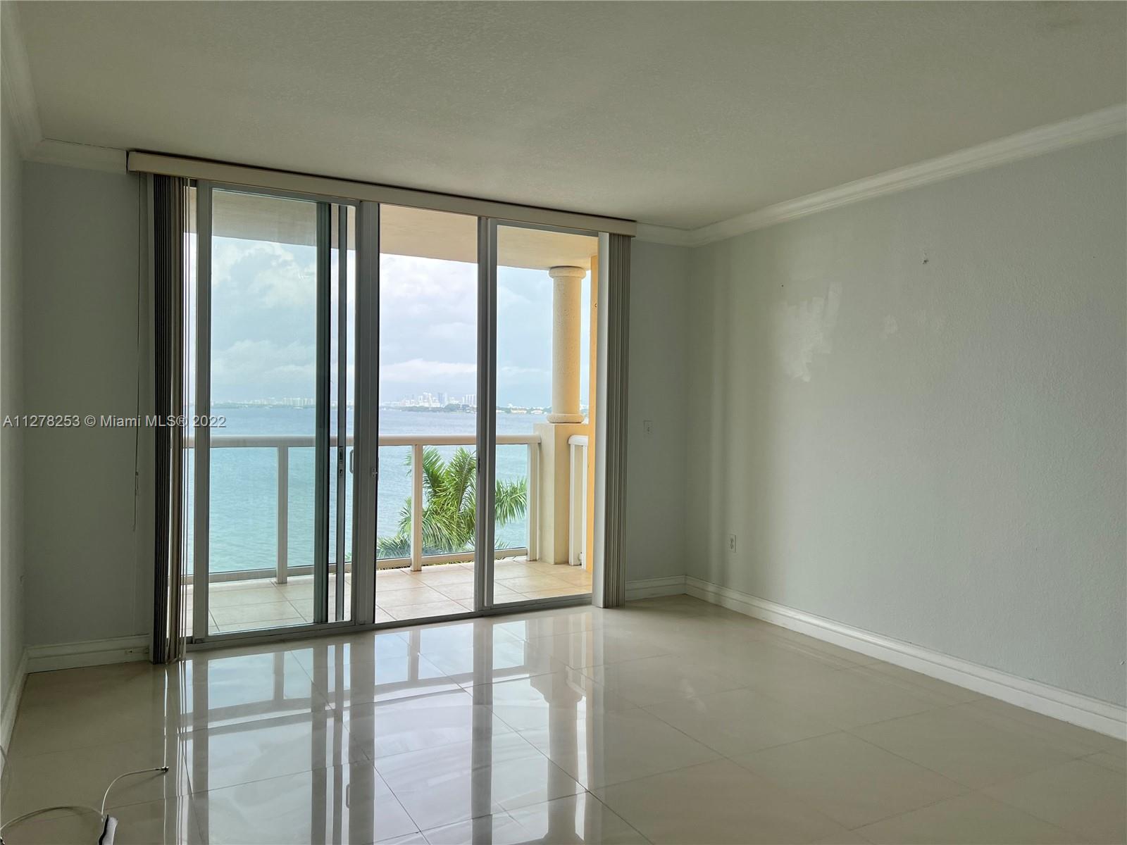 a view of an empty room with wooden floor and windows