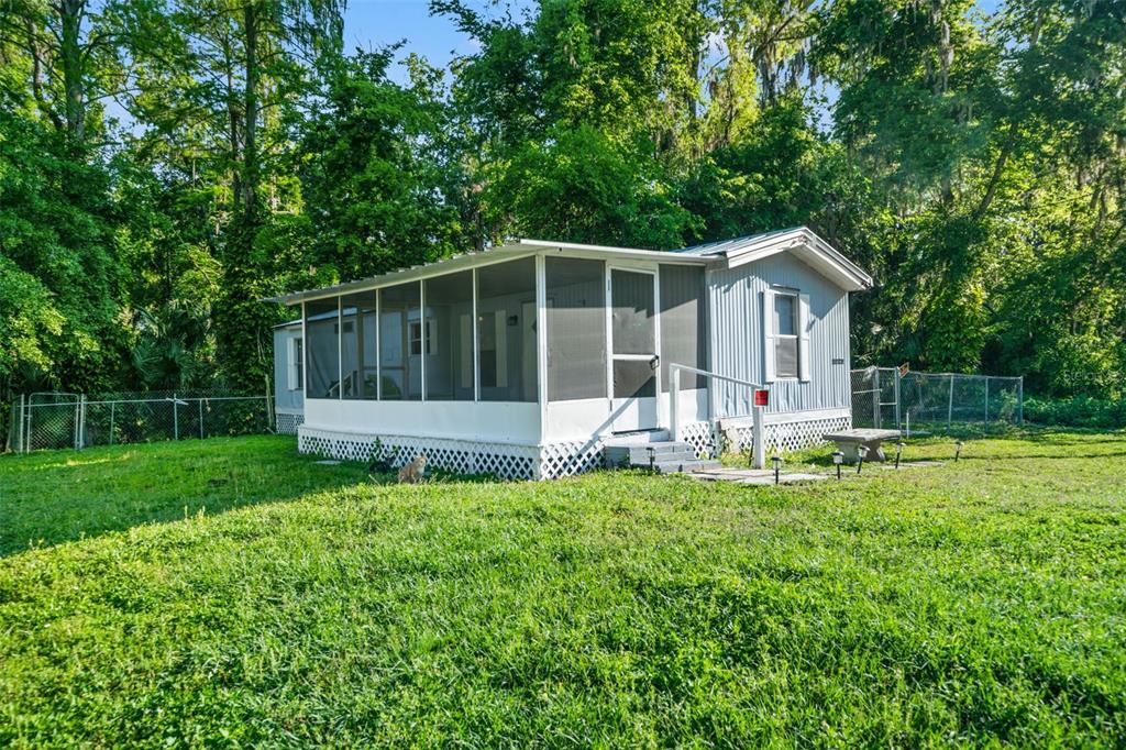 a view of a house with backyard and sitting area