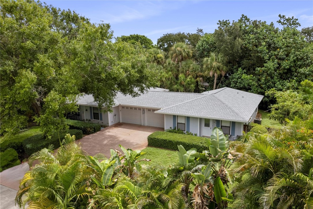 an aerial view of a house with yard and green space