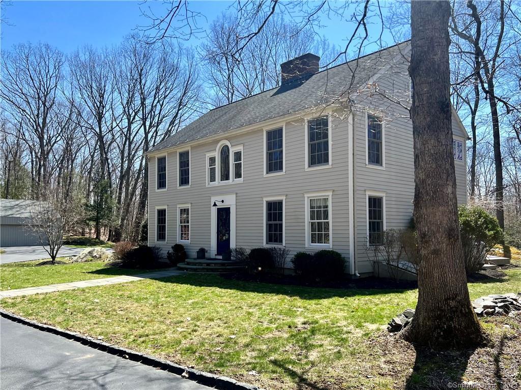 a front view of a house with a yard and trees