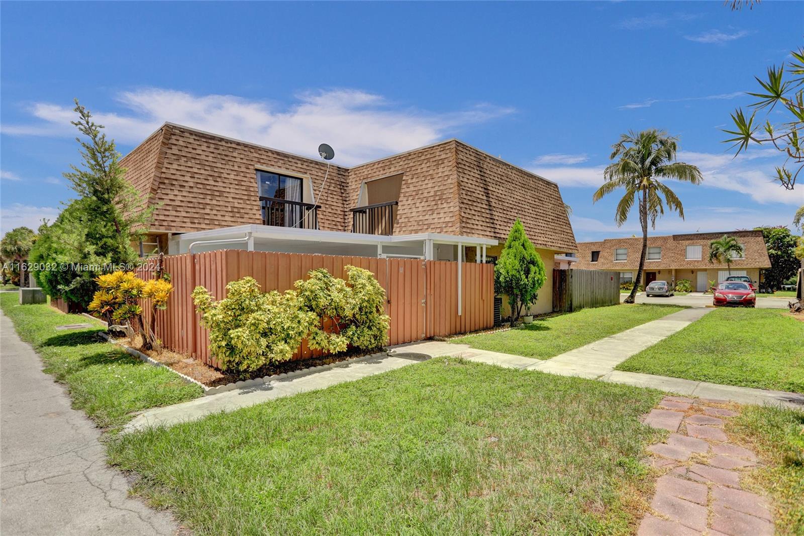 a front view of a house with a yard and potted plants