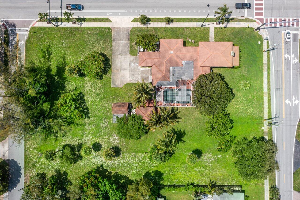 an aerial view of residential house with outdoor space and trees all around