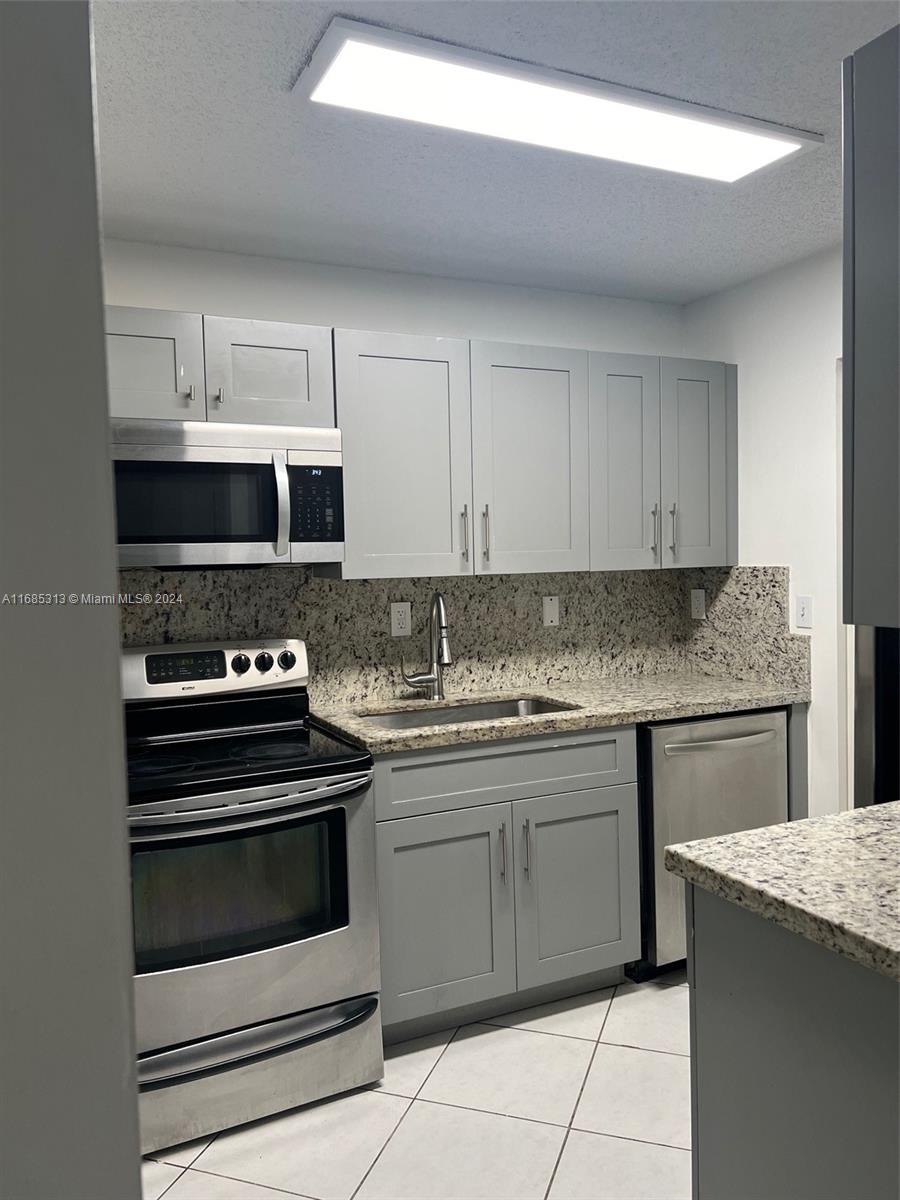 a kitchen with stainless steel appliances granite countertop a stove and a sink