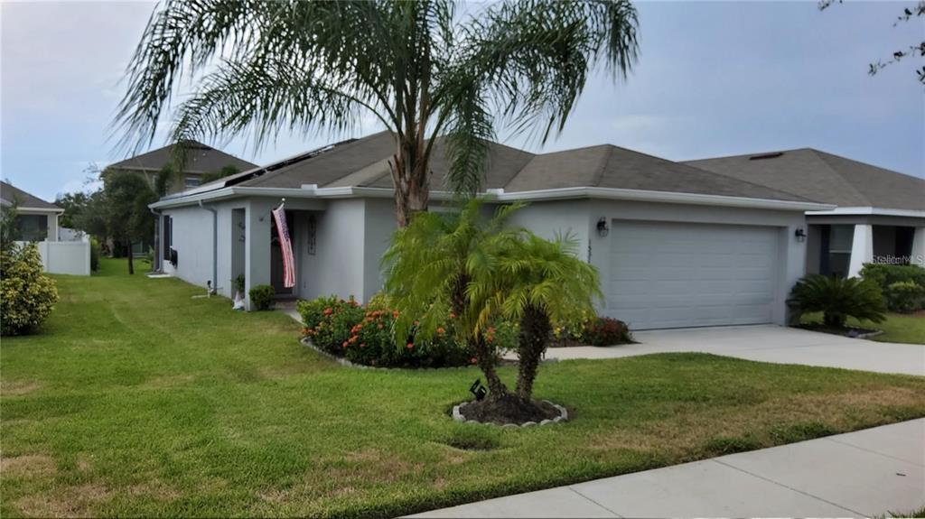 a front view of a house with a garden and plants