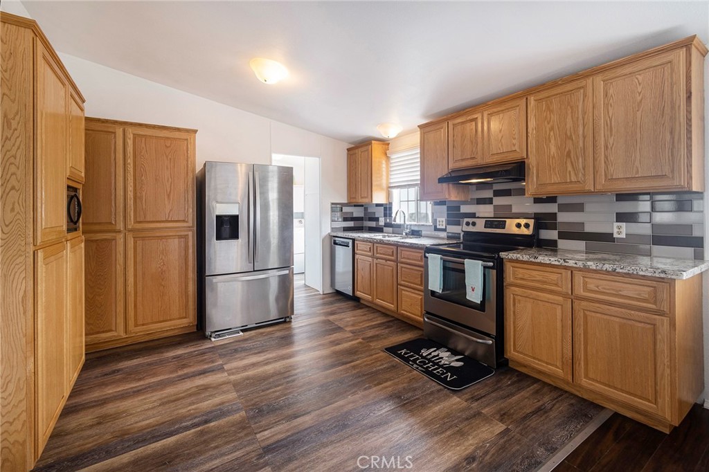 a kitchen with stainless steel appliances a refrigerator sink and cabinets