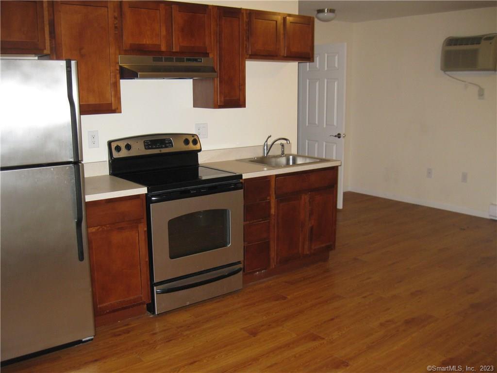 a kitchen with stainless steel appliances a stove a microwave and a hard wood floors