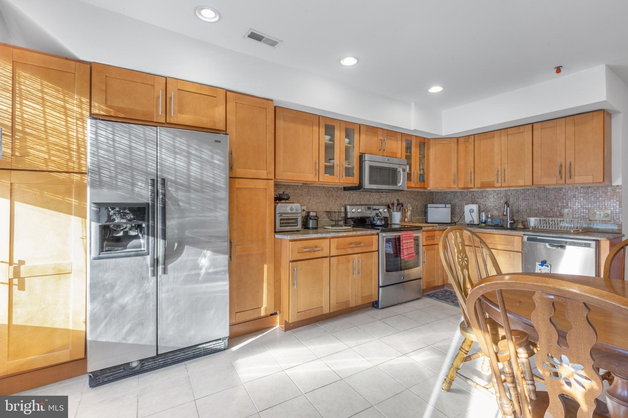 a kitchen with stainless steel appliances granite countertop a stove a sink and a refrigerator