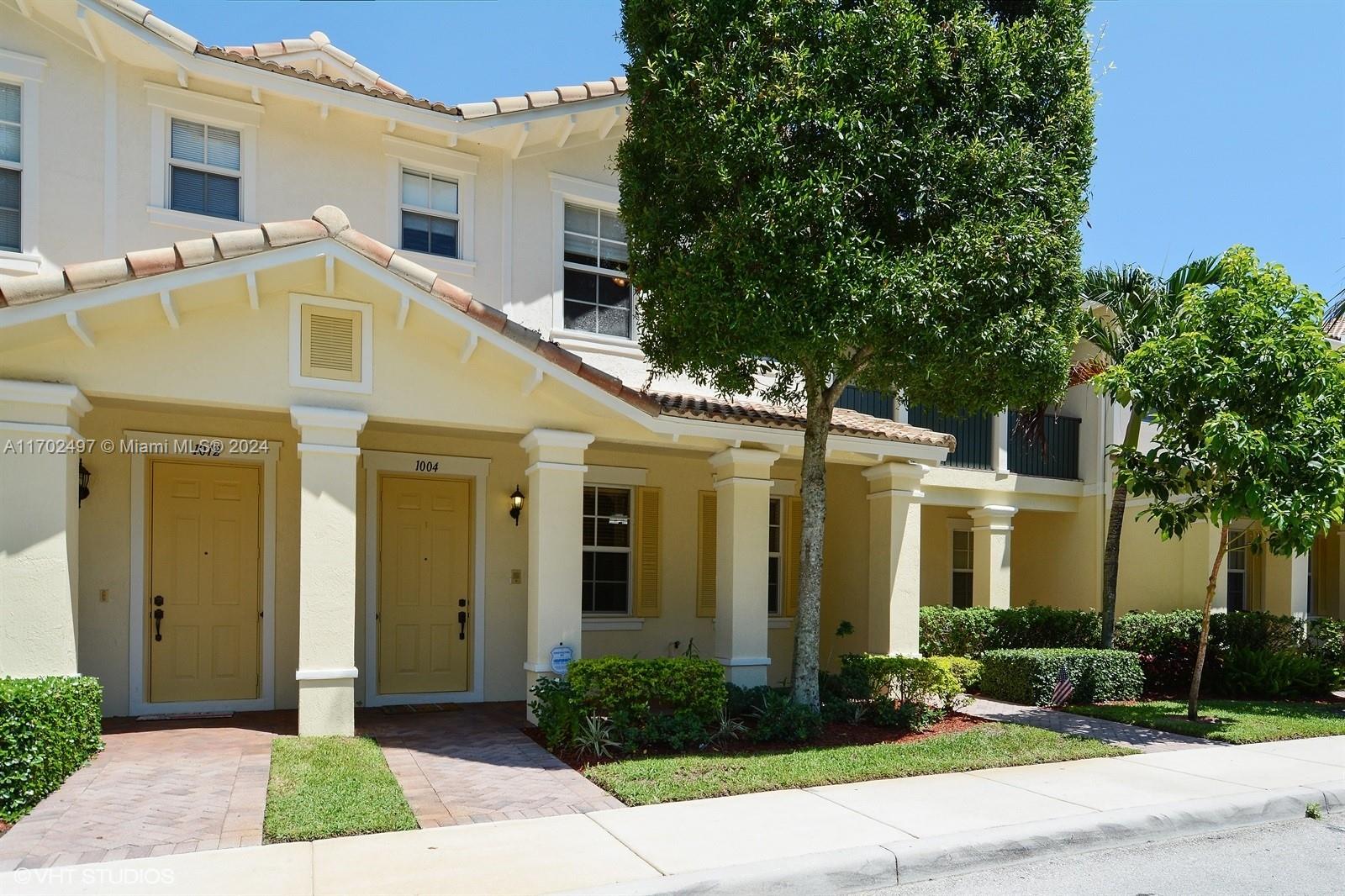 a front view of a house with yard and green space