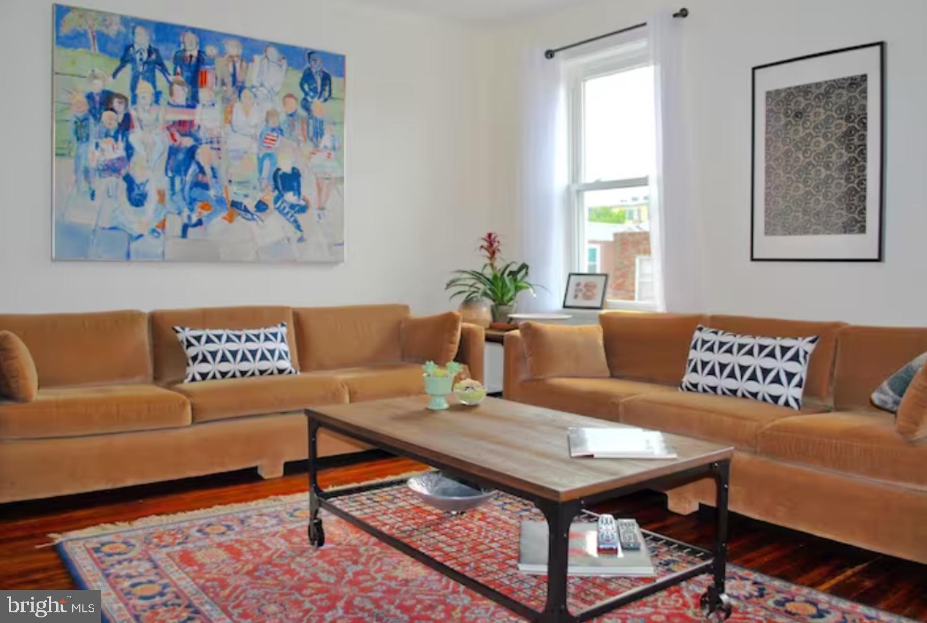 a living room with a couch and paintings on the wall