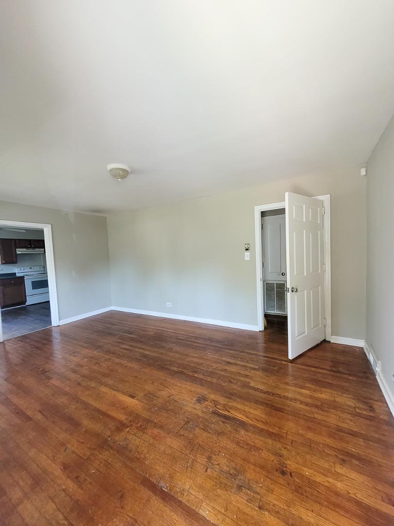 a view of empty room with wooden floor