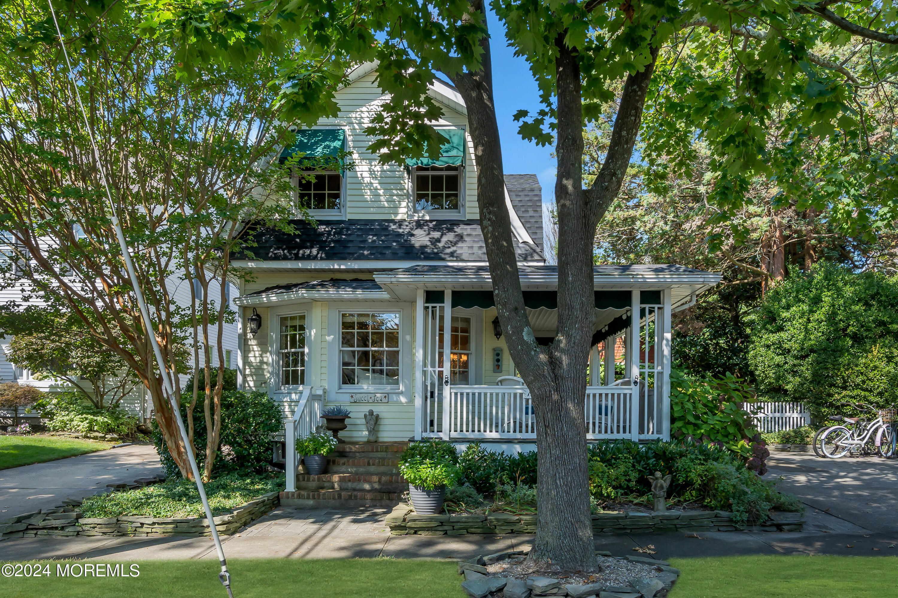 a front view of a house with yard tree and green space