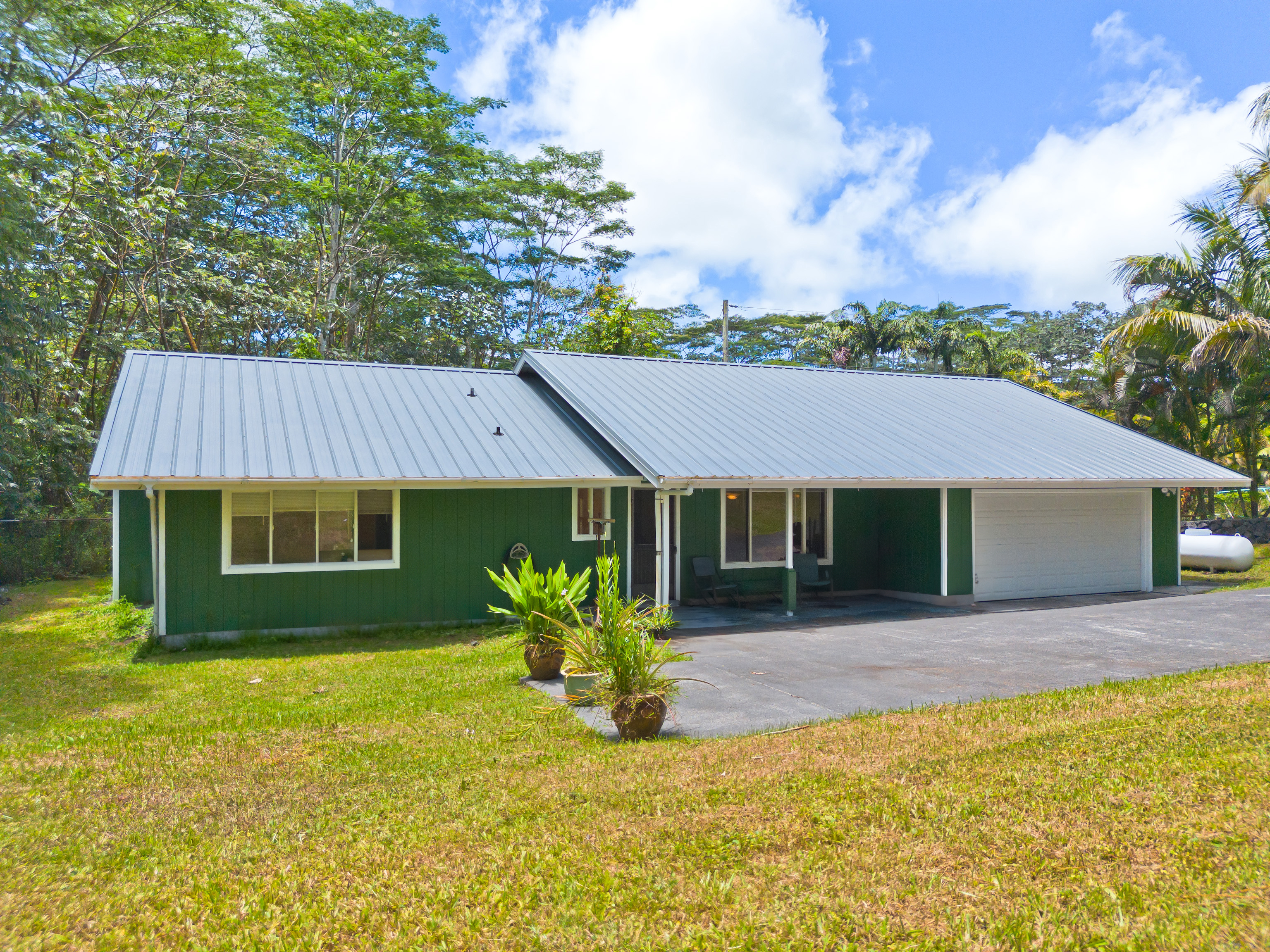 a front view of house with yard and trees in the background