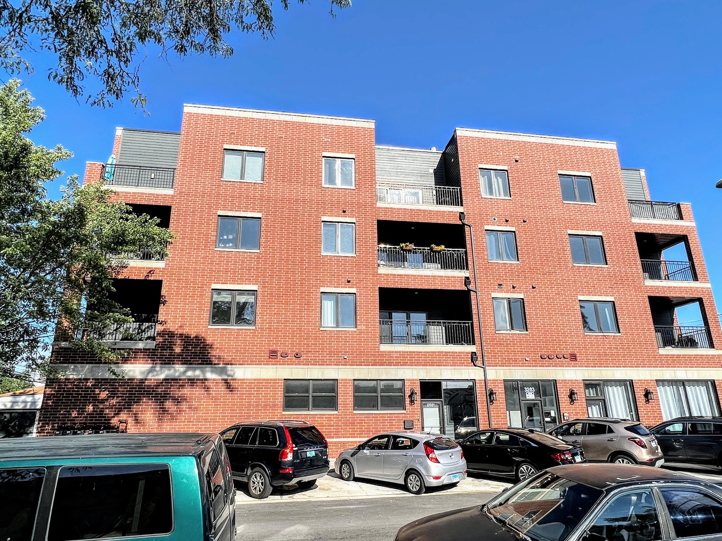 a front view of a residential apartment building with a yard