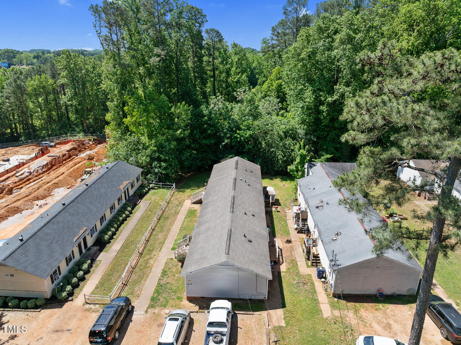 an aerial view of a residential houses with outdoor space and trees