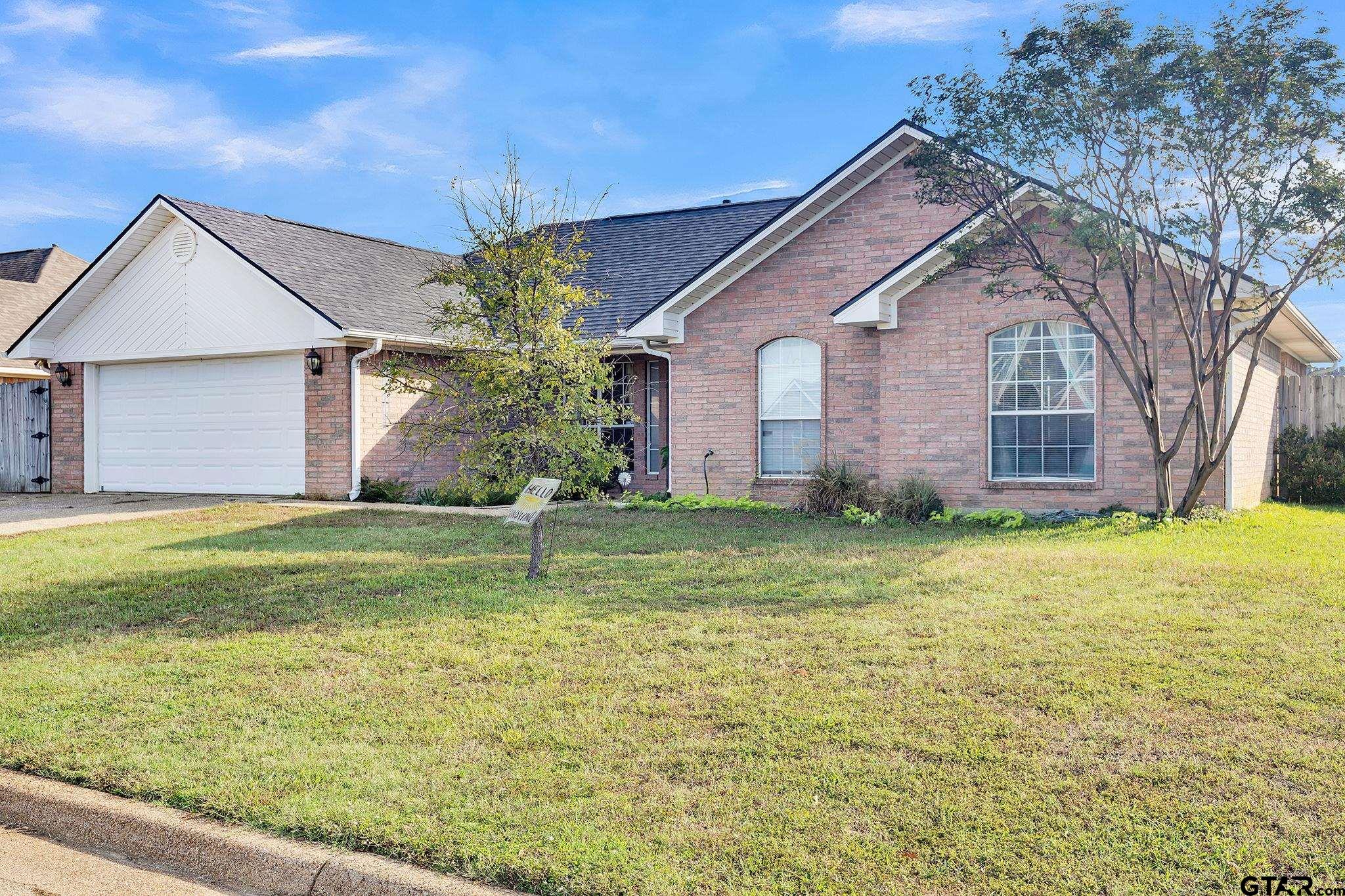 a front view of house with yard and garage