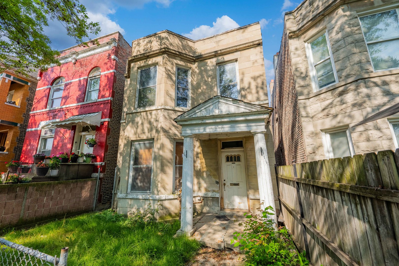 a view of a brick house with many windows next to a road