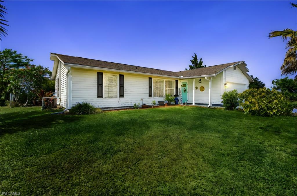 a front view of a house with a yard and trees