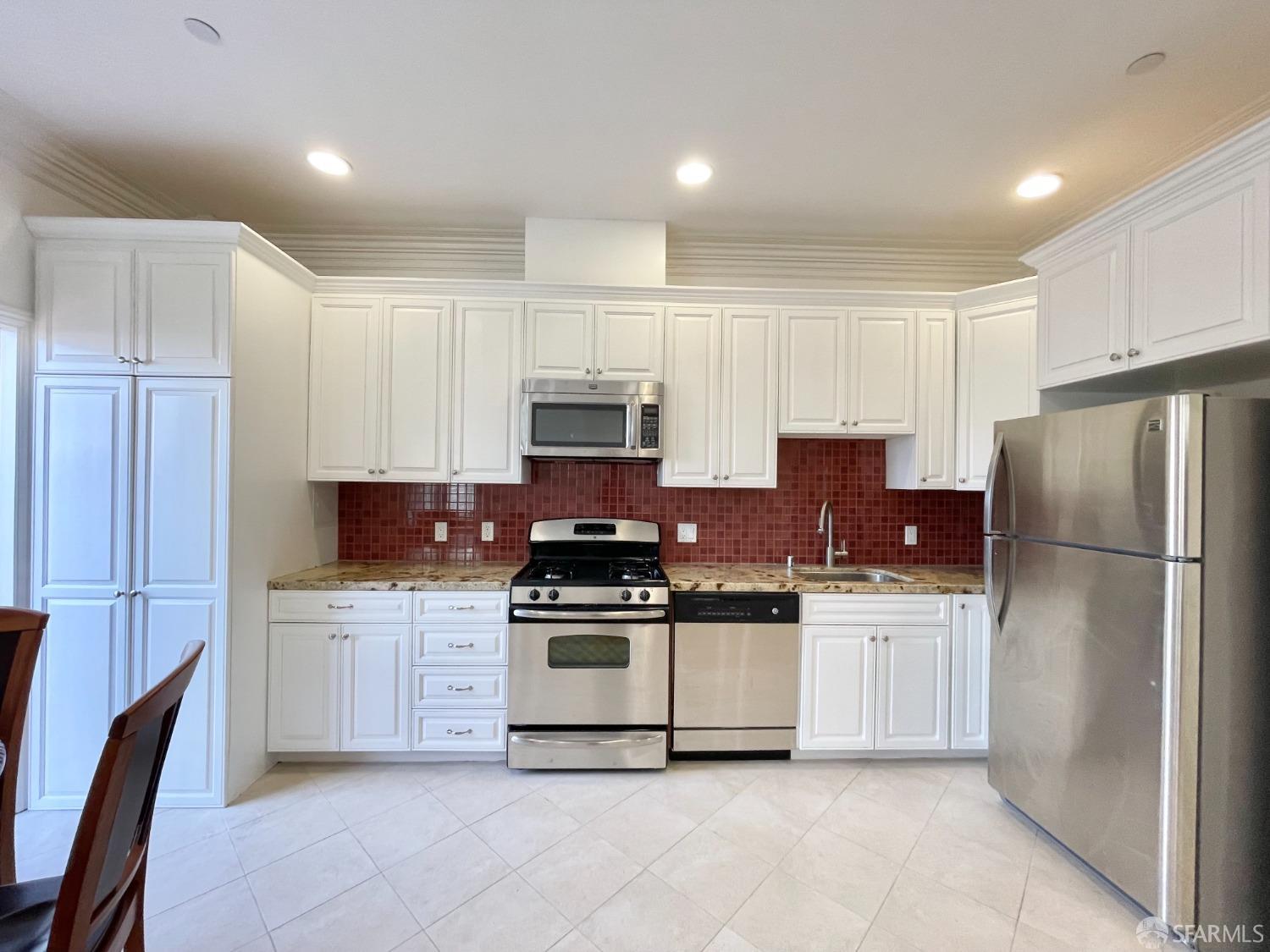 a kitchen with cabinets stainless steel appliances and a counter space