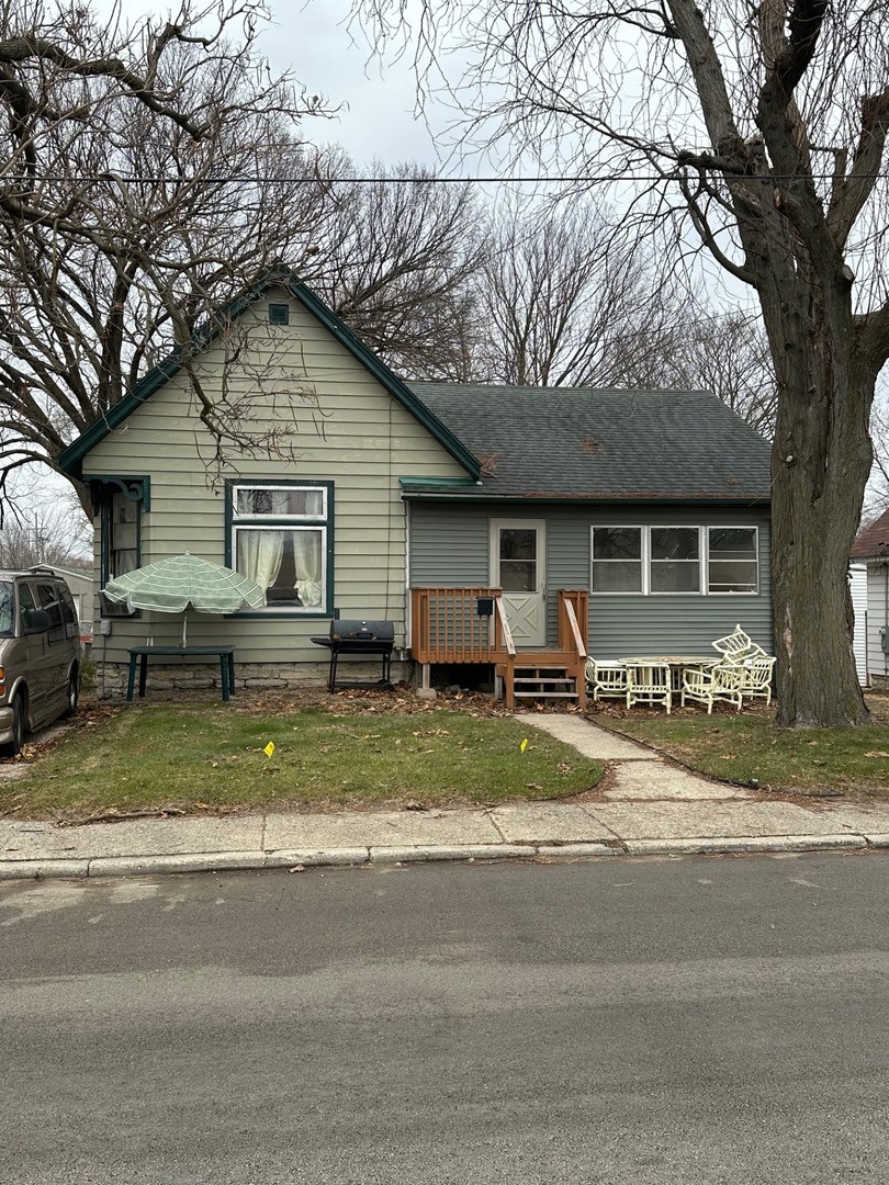 a view of a house with a yard and large tree