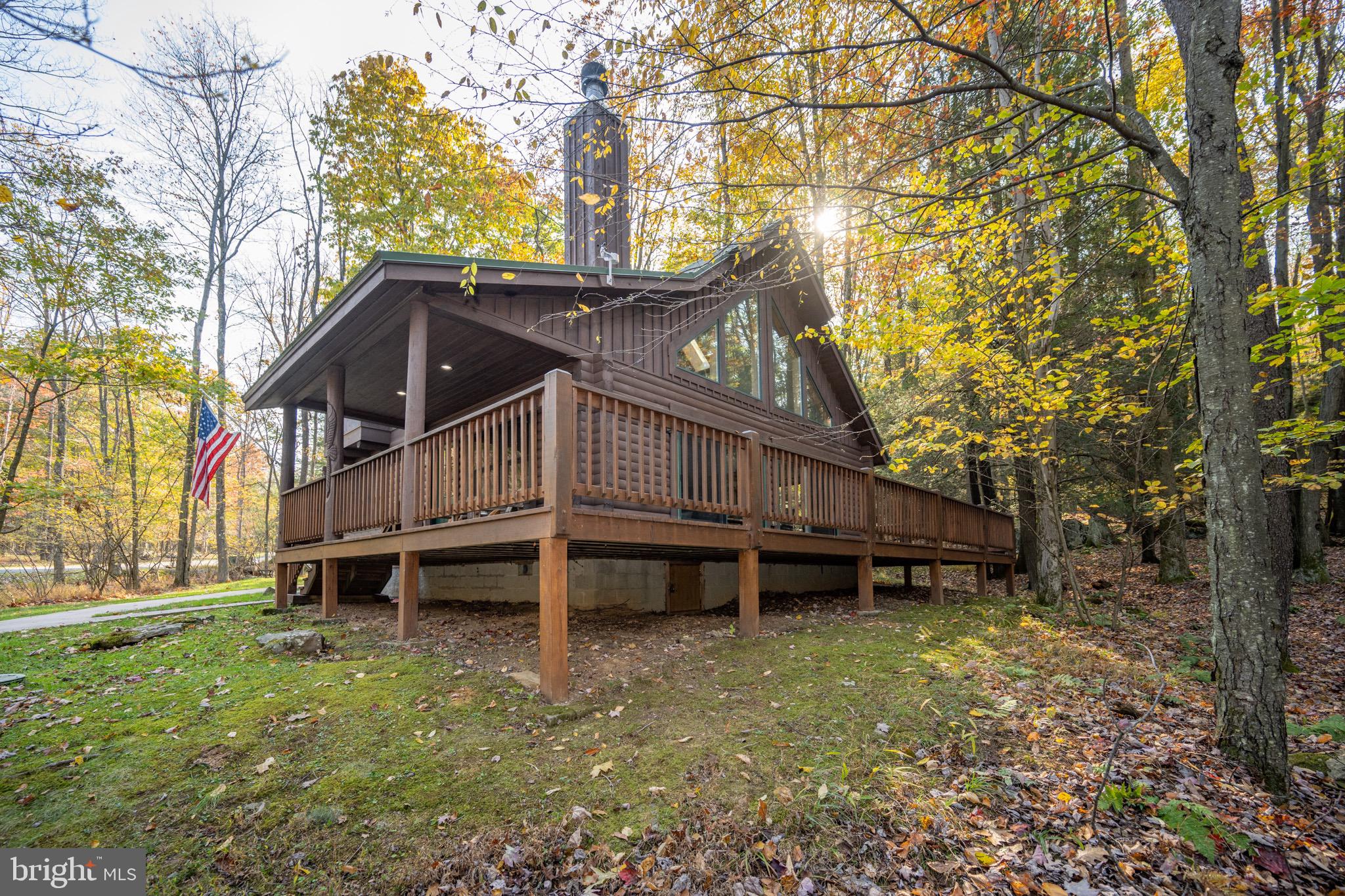 a view of a house with a yard and a wooden deck