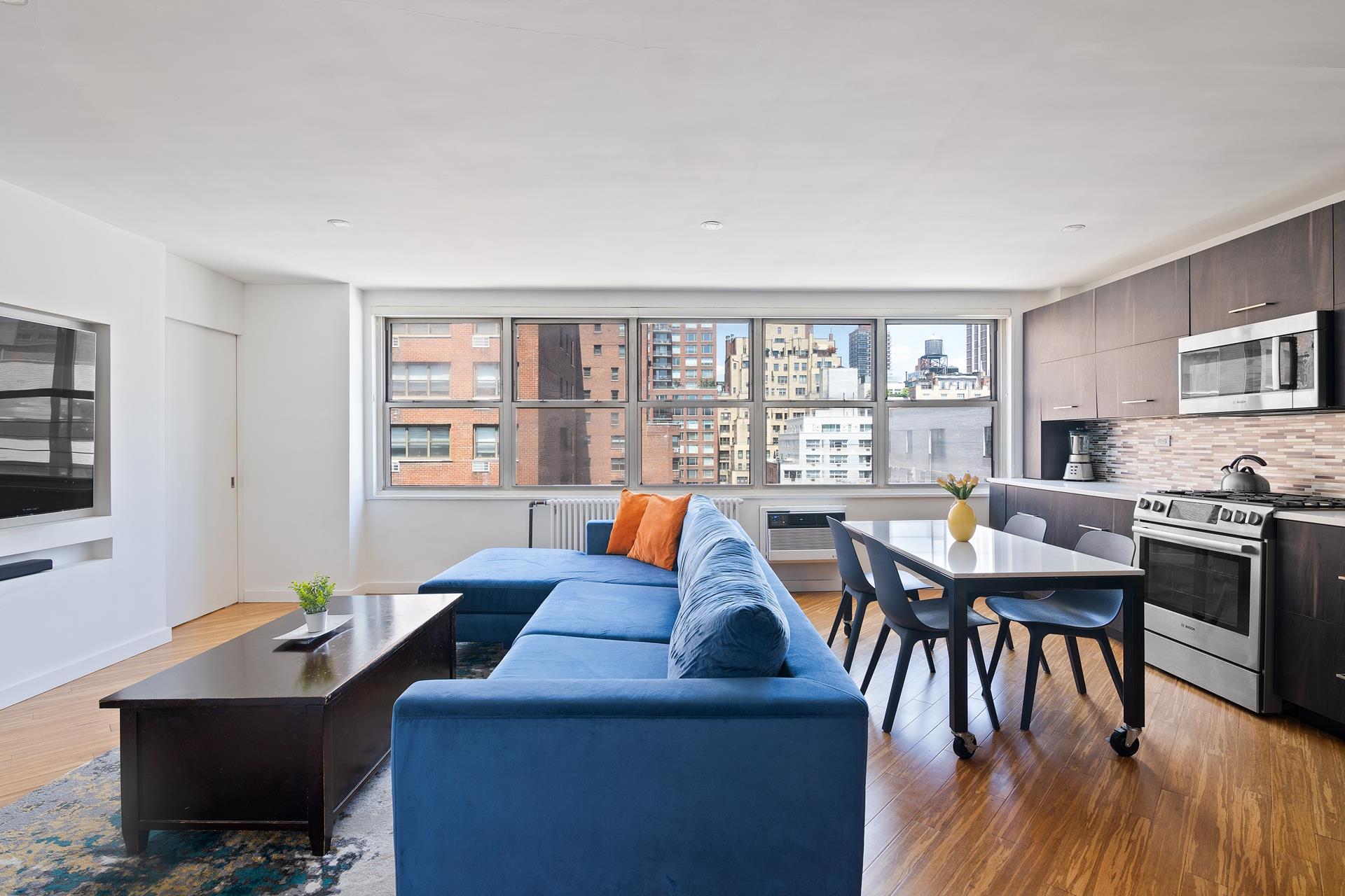 a living room with furniture a desk and a flat screen tv