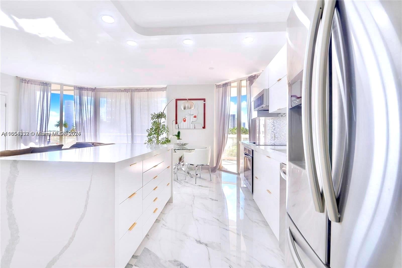 a large white kitchen with a large window