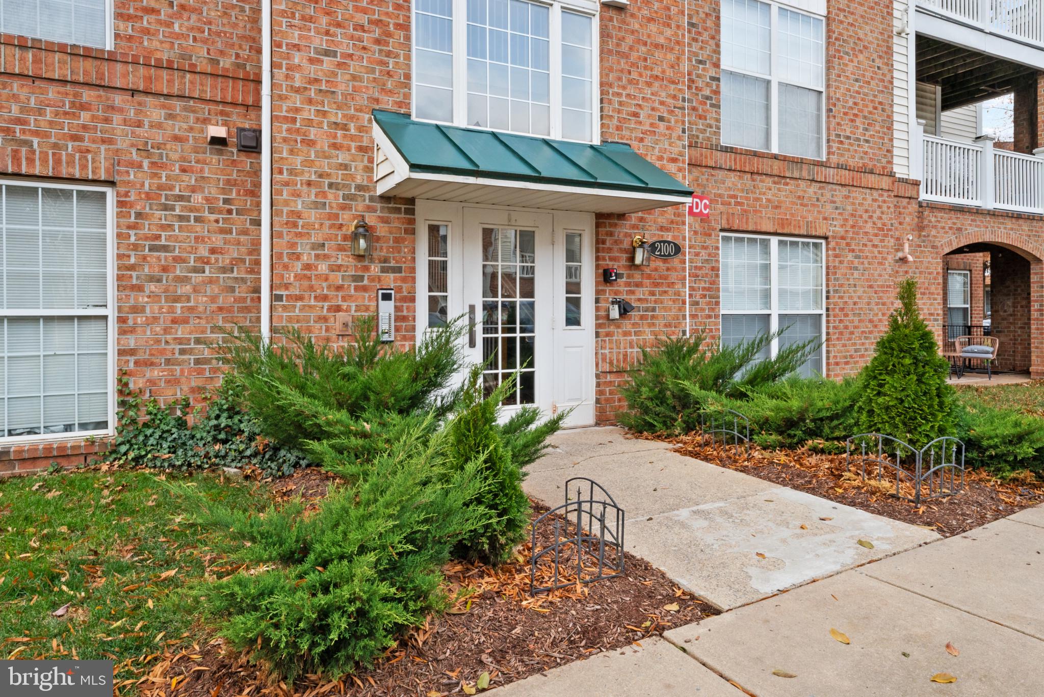 front view of a brick house with a small yard