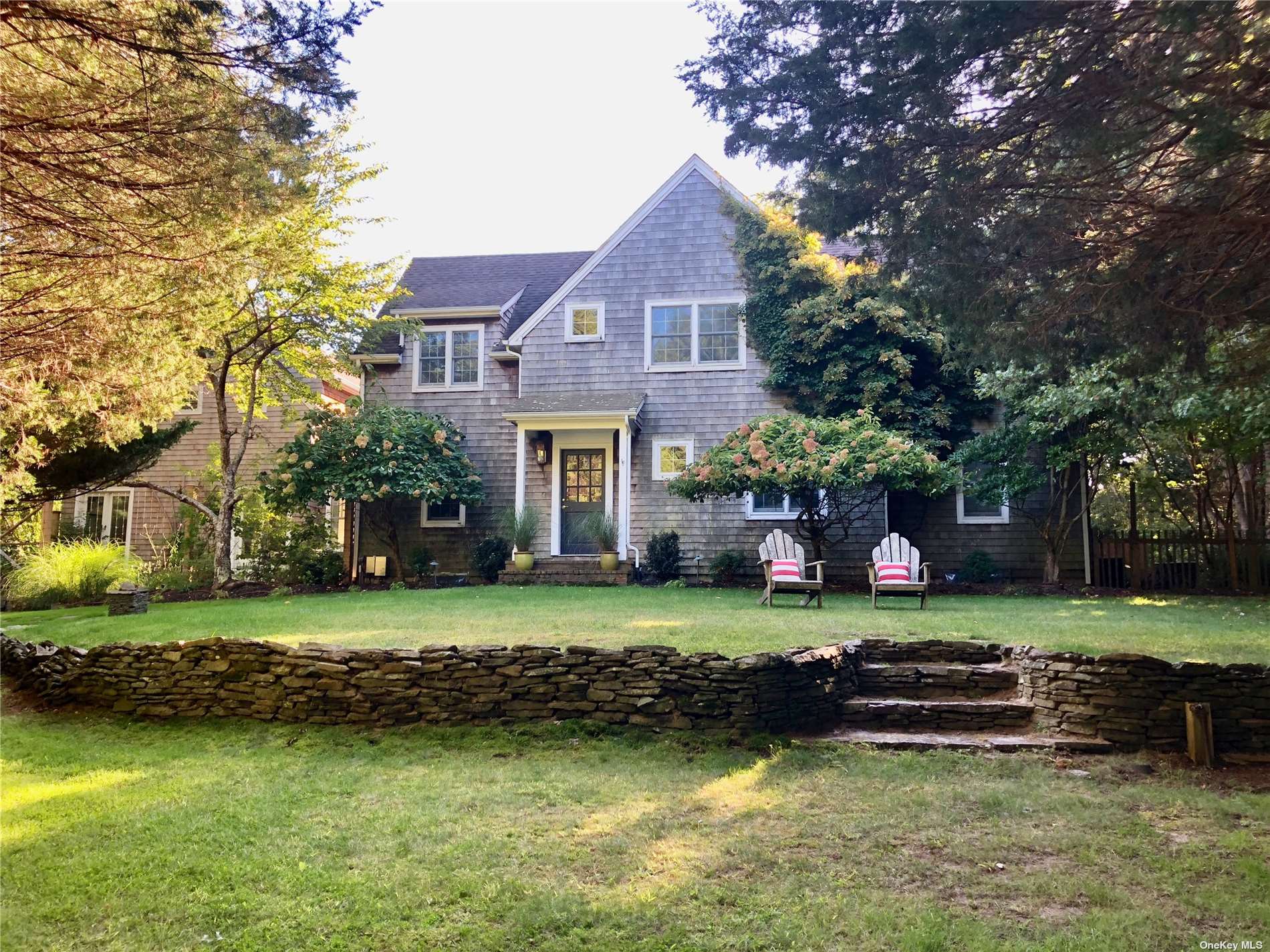 a view of a big house with a big yard and large trees