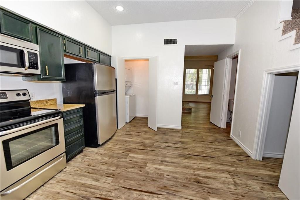 a kitchen with stainless steel appliances granite countertop a refrigerator and a stove top oven