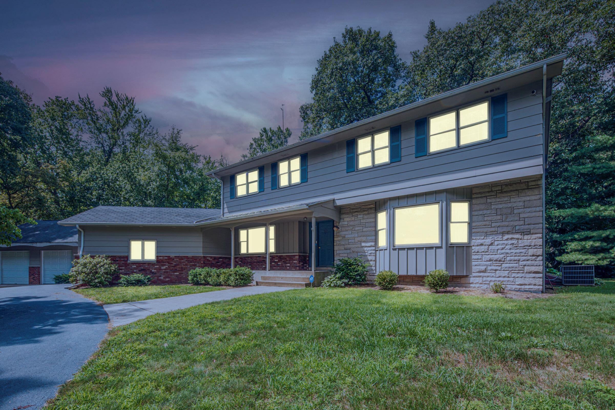 a front view of a house with a yard and outdoor seating