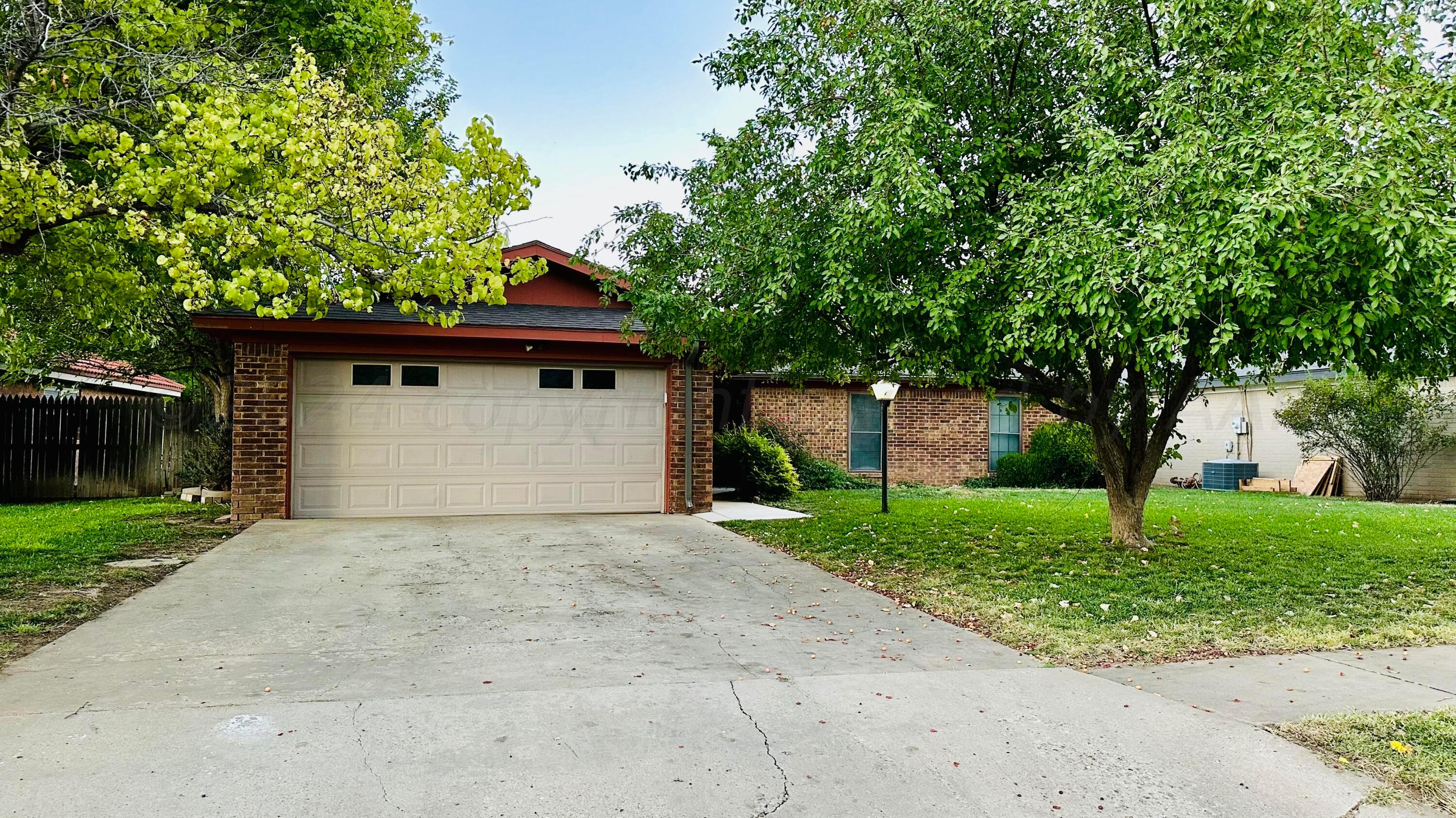 a front view of a house with a garden and trees