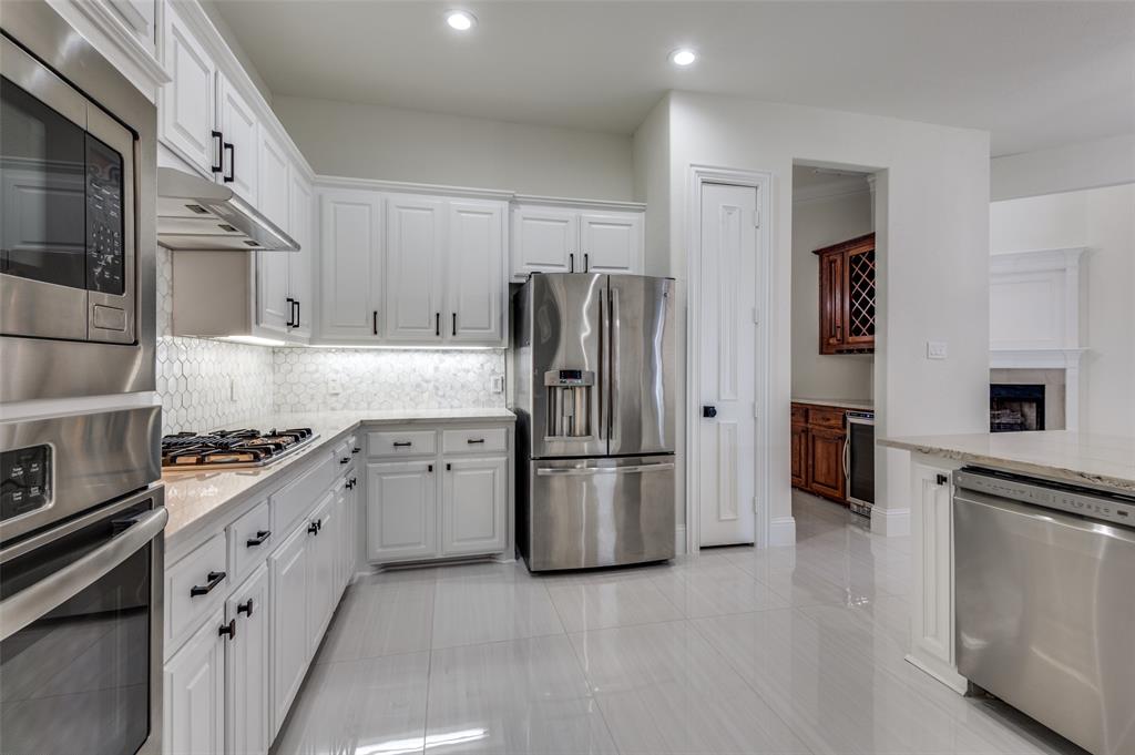 a kitchen with stainless steel appliances granite countertop a refrigerator and a stove