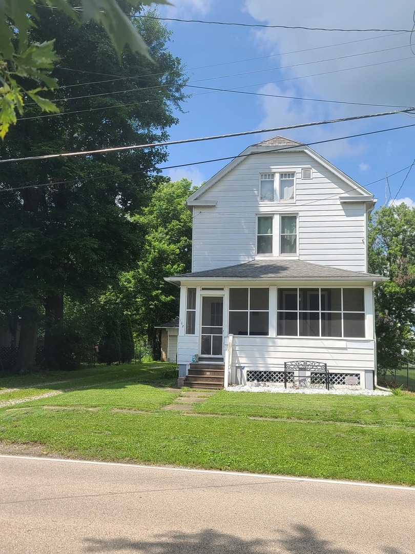 a front view of a house with a garden and trees