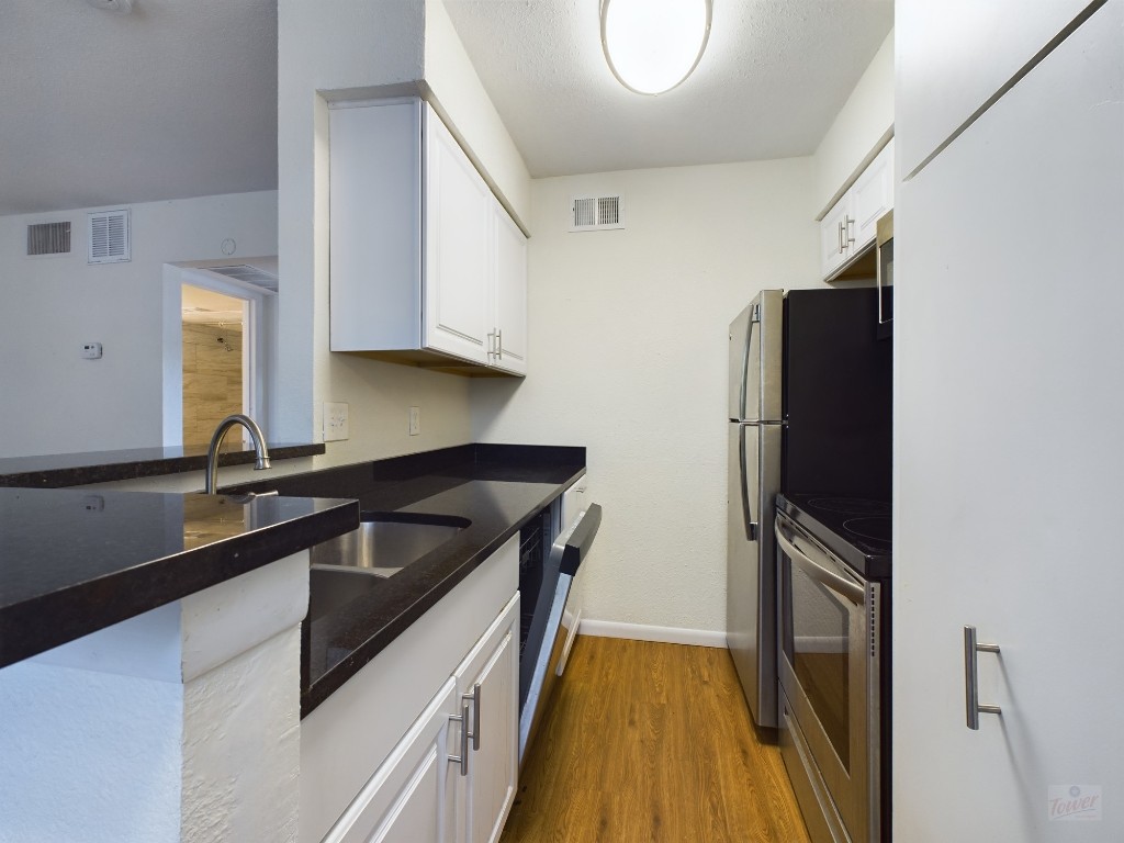 a kitchen with granite countertop a refrigerator and a sink