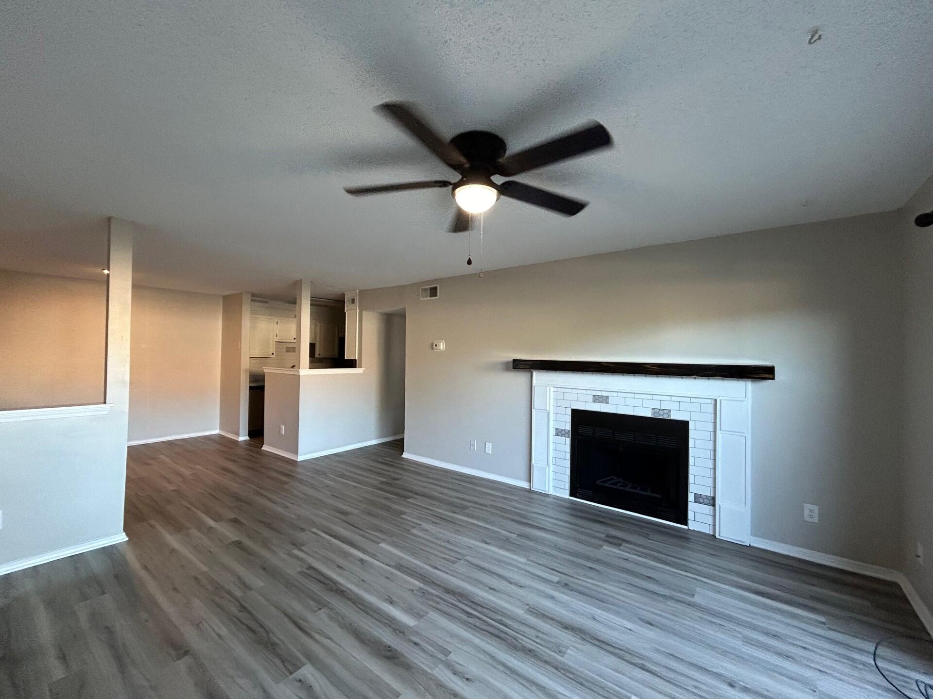 a view of an empty room with a fireplace and a window