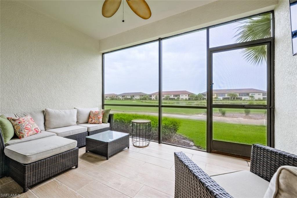 a living room with furniture and floor to ceiling windows