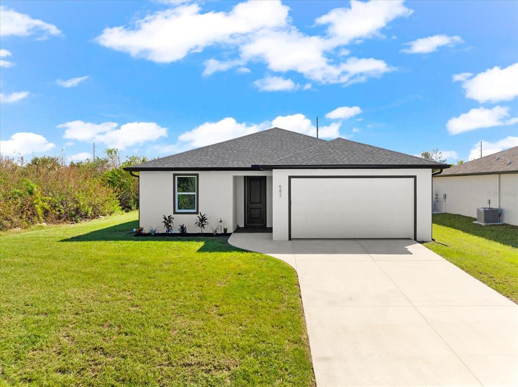 a front view of a house with yard and garage