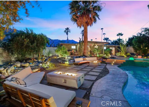 a view of a patio with swimming pool lawn chairs and a fire pit