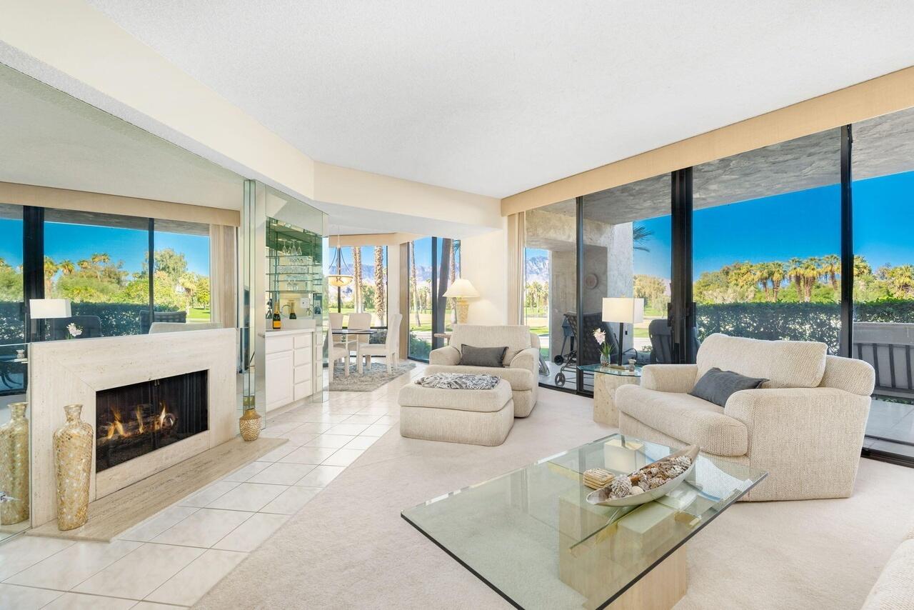 a living room with furniture large windows and a fireplace