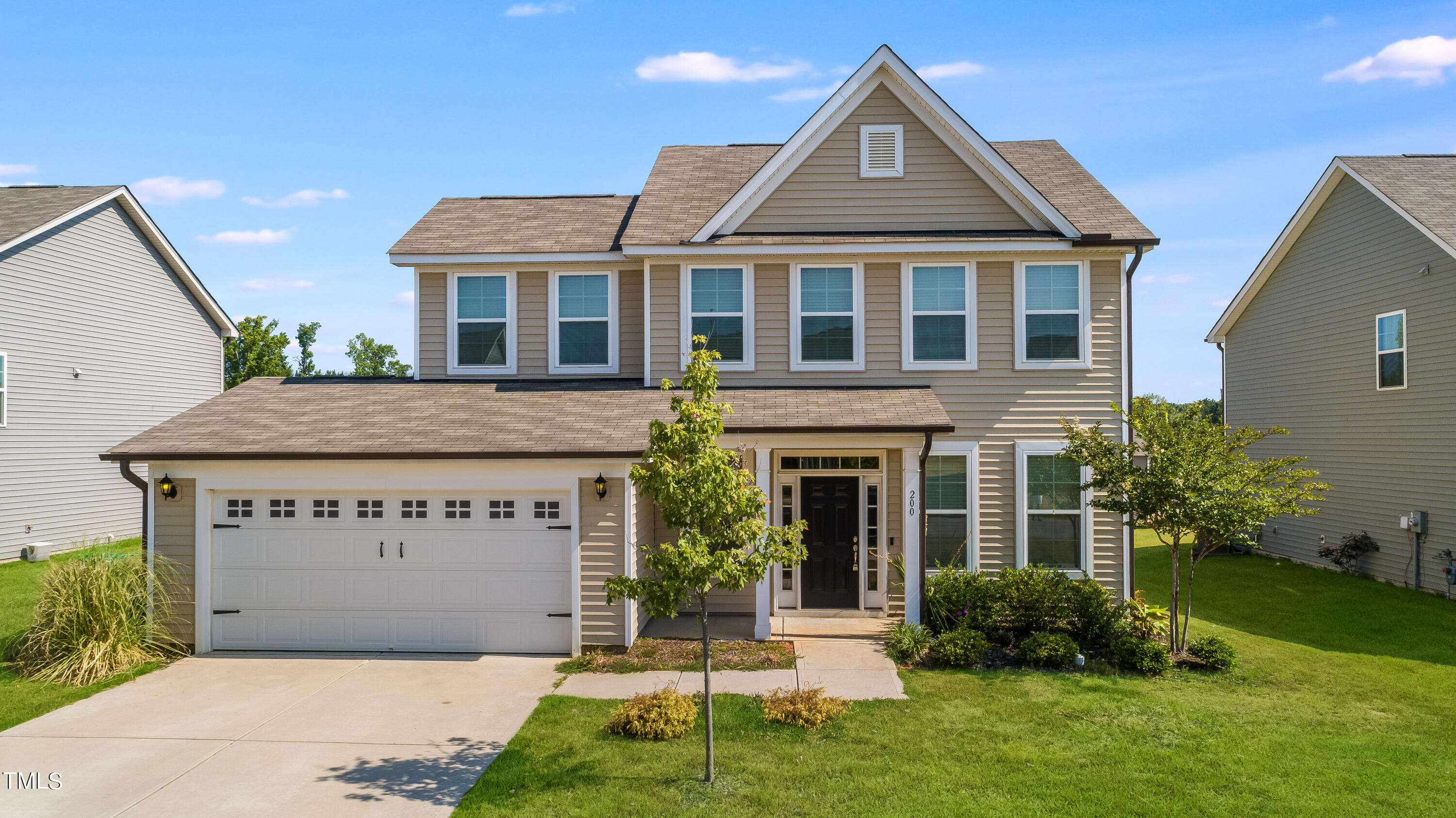 a front view of a house with a yard and garage