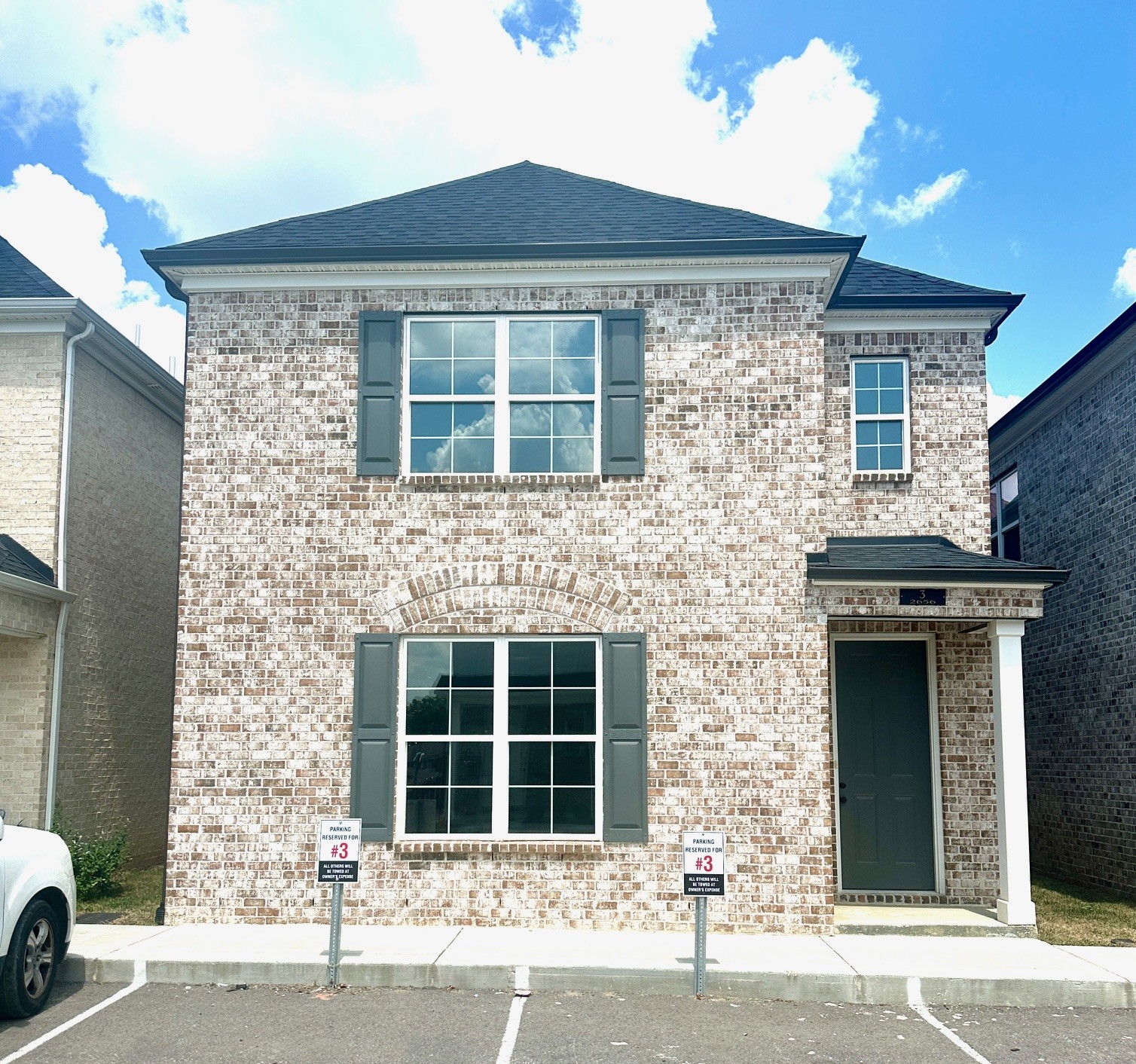 a front view of a house with a parking space