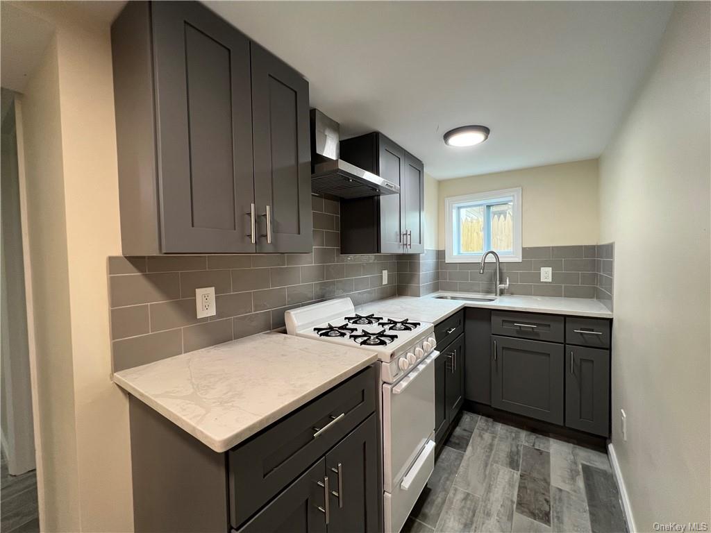 a kitchen with granite countertop a sink stove and cabinets