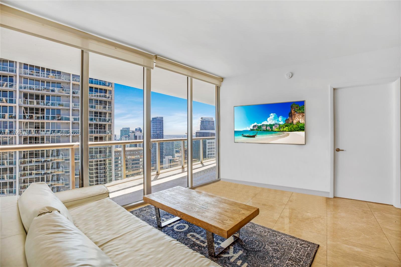 a living room with furniture a rug and a floor to ceiling window