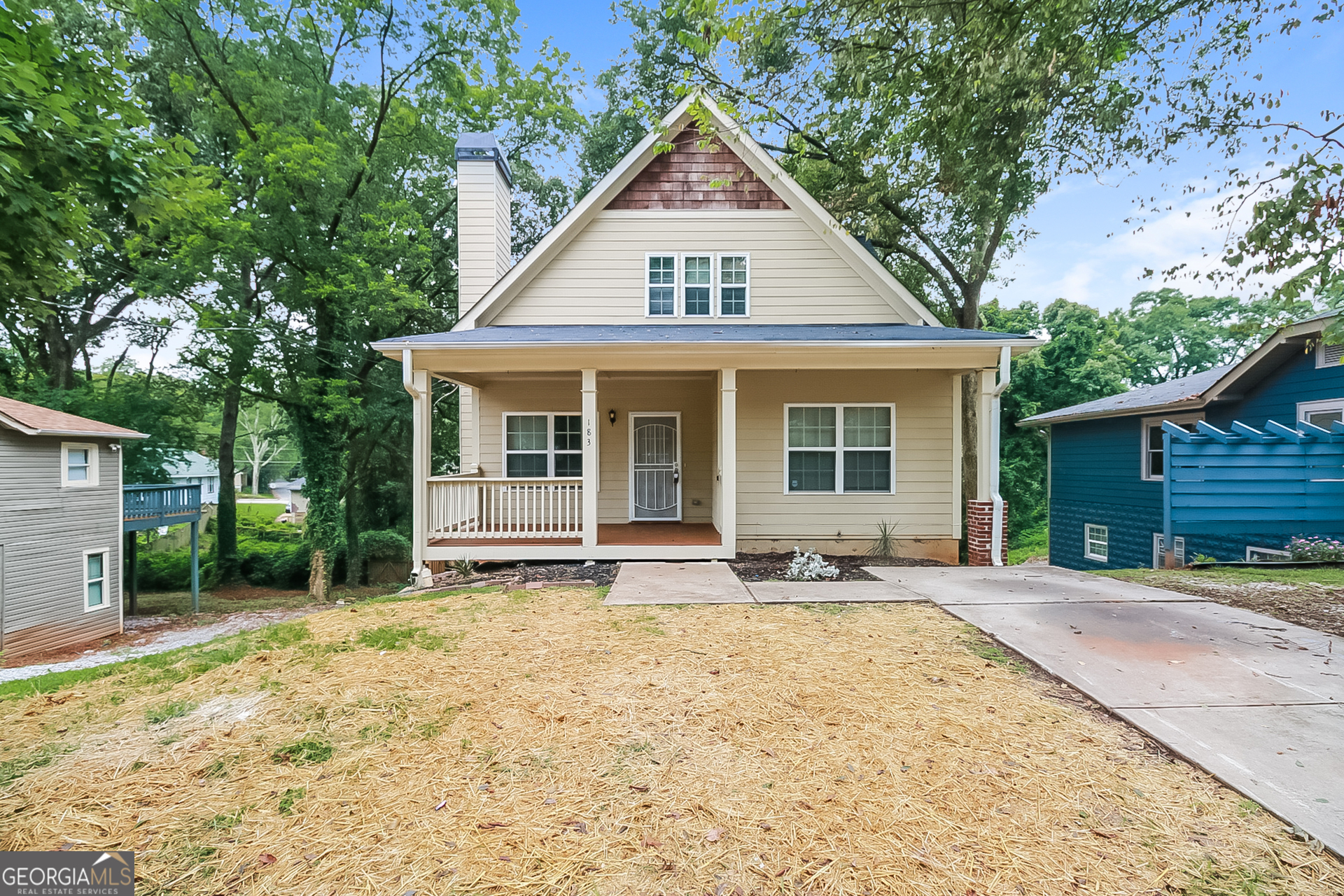 a front view of a house with a yard and seating space